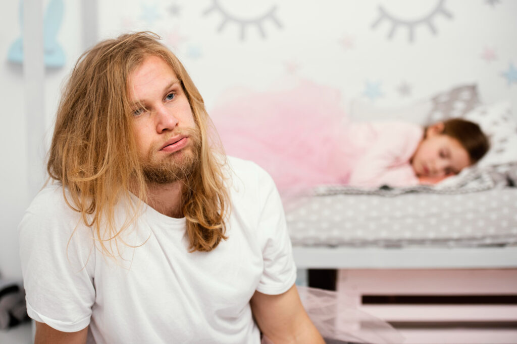 padre agotado intentando despertar a su hija